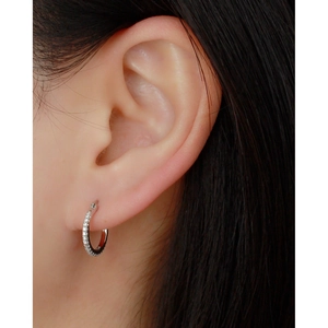 Macro shot of S925 sterling silver hoop earring with sparkling clear cubic zirconia stones