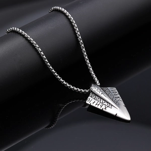 Macro detail of Viking spearhead pendant with Norse runes on stainless steel box chain