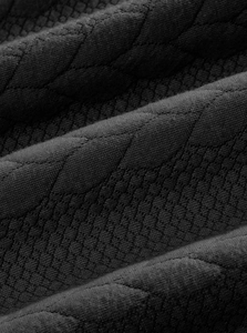 Close-up of black quilted knit fabric with hexagonal texture on vintage sweatshirt