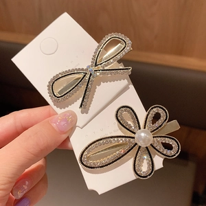 Detail of Korean style black bow and pearl flower hair clips with sparkling rhinestones