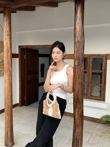 Detail of handmade woven cotton rope bag with chic beige and white diamond pattern
