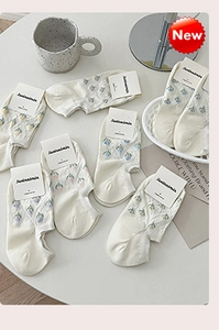 Gros plan de chaussettes en coton blanc à motifs floraux avec emballage de marque