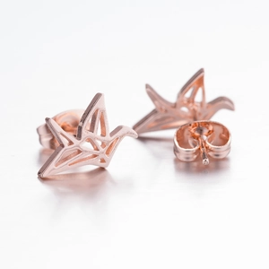 Macro view of rose gold paper crane earrings showing geometric design and secure backings