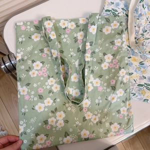 Close-up of green floral canvas tote bag showing detailed flower print and sturdy texture