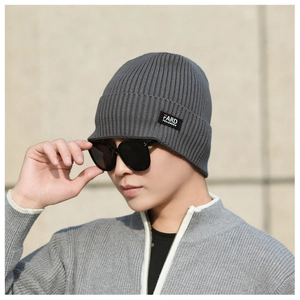 Detail of dark grey ribbed knit beanie showing high-quality texture and brand side label