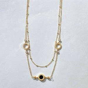 Elegant gold double layer necklace featuring black Roman numeral disc and crystal accents