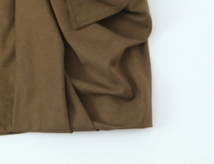 Detailed close-up of brown cotton cargo skirt fabric showing fine stitching and twill texture