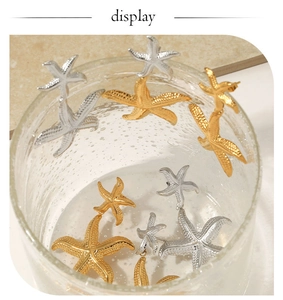 Macro detail of starfish earrings with textured gold and silver finish in creative water setting