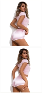 Detail of pink satin yoga shorts and slim crop top showing glossy fabric and fit
