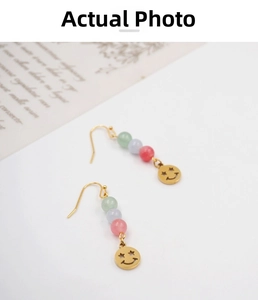 Detailed shot of ethnic style drop earrings with colorful beads and star-eyed smiling face