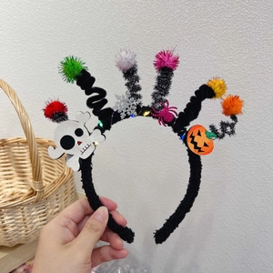 Detail of glowing Halloween headband with colorful pom-poms, glitter skulls and LED lights