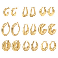 Macro view of 9 pairs golden stainless steel hoop and geometric earrings set