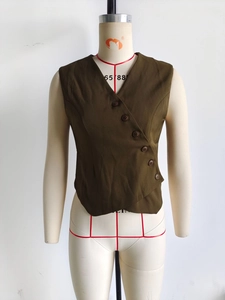 Detail of dark brown vest showing asymmetric six-button closure and suit fabric texture
