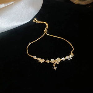 Macro shot of gold-plated cat eye stone bow bracelet with adjustable drawstring chain