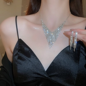 Gros plan d'une parure de mariage avec collier en V scintillant et boucles d'oreilles