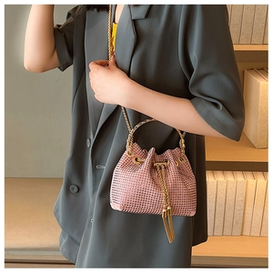 Detail of pink rhinestone bucket bag with golden ring handle and chain strap