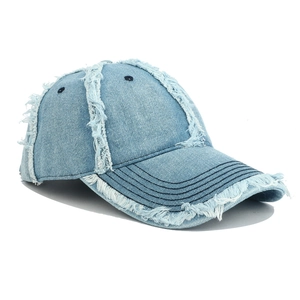 Close-up of distressed frayed edges and washed denim texture on a baseball cap