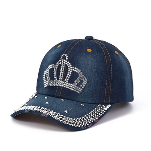 Detail of blue denim baseball cap featuring rhinestone crown motif and sequined brim
