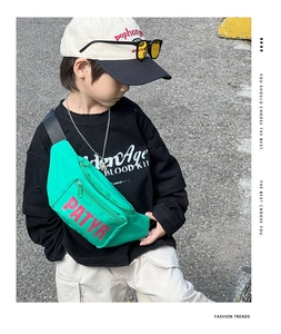 Detail of neon green kids fanny pack with red letters on durable nylon material