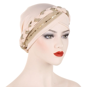 Detail of beige turban hat featuring intricate braided bands and shimmering gold sequins