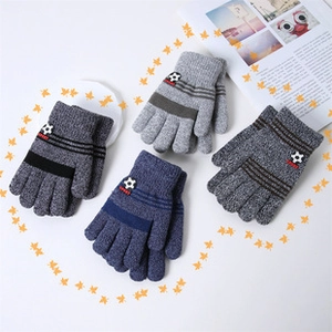 Flat lay of colorful thick knitted kids gloves with soccer sport patches and stripe cuffs