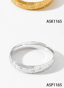 Detail of gold and silver stainless steel wide bangles with vine pattern and zircons