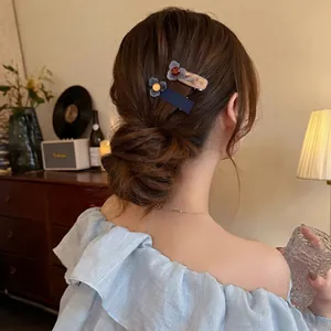 Elegante set di fermagli per capelli con fiori blu e lavanda su uno chignon basso chic