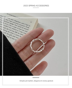 Detailed view of silver faceted beaded elastic ring worn on hand with a minimalist design