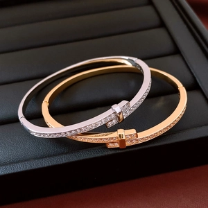 Close-up of 18K gold and silver plated bangle bracelets featuring zircon inlay on a jewelry box
