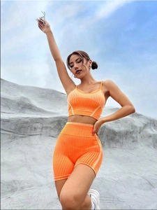 Dettaglio del set yoga a coste arancione con texture elastica su top e pantaloncini a vita alta