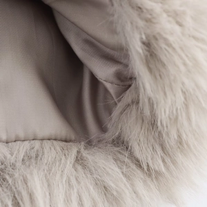 Detailed close-up of soft greige faux fur texture and smooth inner lining of the jacket