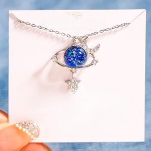 Detail of s925 silver necklace with blue starry globe and sparkling moon star pendant
