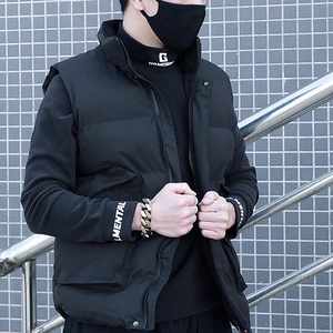 Detail of men's black puffer vest with large utility pockets and golden Cuban chain bracelet