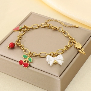 Détail de breloques fruits et pendentifs émail sur un bracelet en acier inoxydable doré