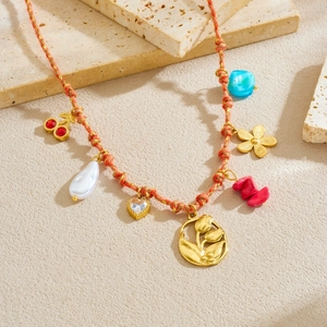 Bohemian orange woven rope necklace with gold tulip charms and colorful gemstone pendants