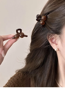 Vue détaillée d'une mini pince à cheveux en résine ambrée pour un style quotidien élégant