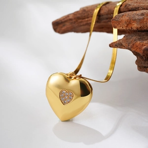 Detail of 18K gold heart locket with pavé rhinestones on snake chain with wood background