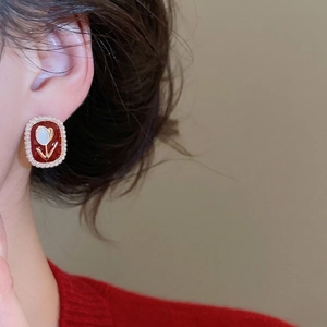 Vintage oval red enamel tulip earrings with white pearl border worn by model