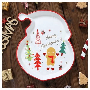 Close-up of Santa hat shaped ceramic Christmas plate with gingerbread man painted design