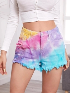 Detailed shot of tie-dye denim shorts featuring distressed holes and frayed hems