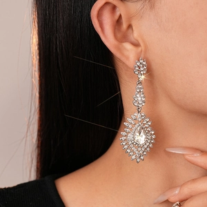 Gros plan sur les boucles d'oreilles pendantes en argent avec zircone poire et halo fleuri