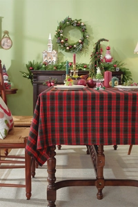 Detailed view of Christmas red and green plaid tablecloth with festive decor on table