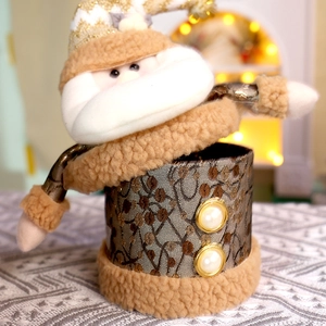 Dettaglio della scatola di caramelle Babbo Natale dorata con ricami e perle finte
