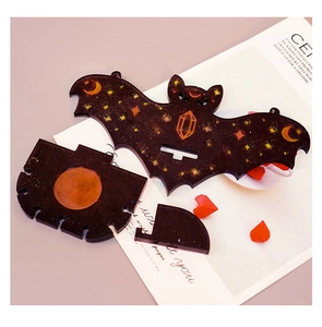 Macro view of bat-shaped glitter resin display stand pieces with moon and star patterns