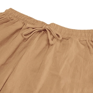 Detail of khaki linen trousers featuring an elastic drawstring waist and side pockets