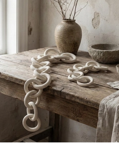 Close-up of matte ceramic chain rings with grainy texture in a wabi-sabi decor style