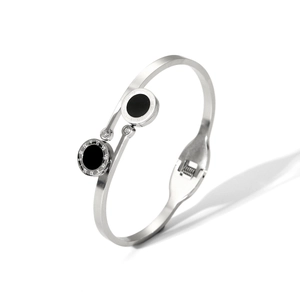 Detailed macro view of silver steel bangle featuring black Roman numeral disc and crystals