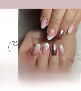 Close-up of pink gradient French press-on nails with rose gold glitter and tiny rhinestones
