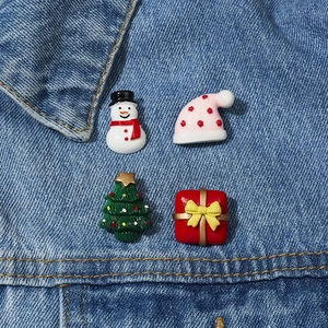 Set mit 4 Weihnachts-Acryl-Broschen mit Schneemann und Baum auf einer Jeansjacke