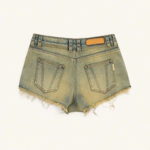 Close-up of vintage blue denim shorts with frayed hems and leather logo patch on back
